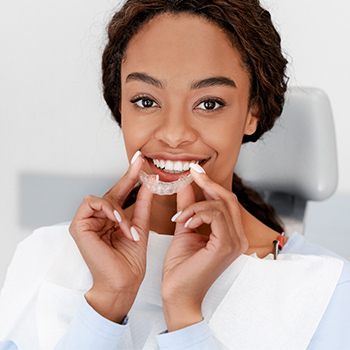 A woman holding invisalign aligners